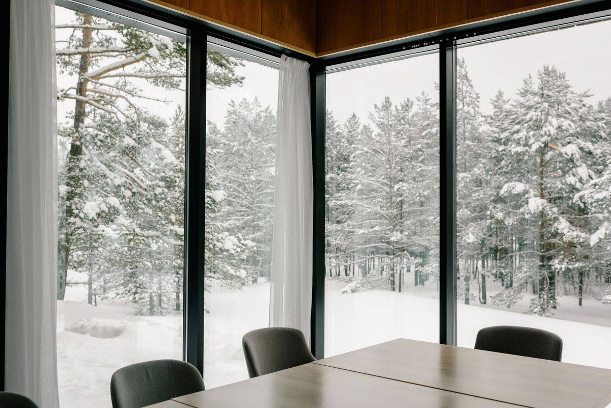 Conference room with floor-to-ceiling windows onto snowy woods