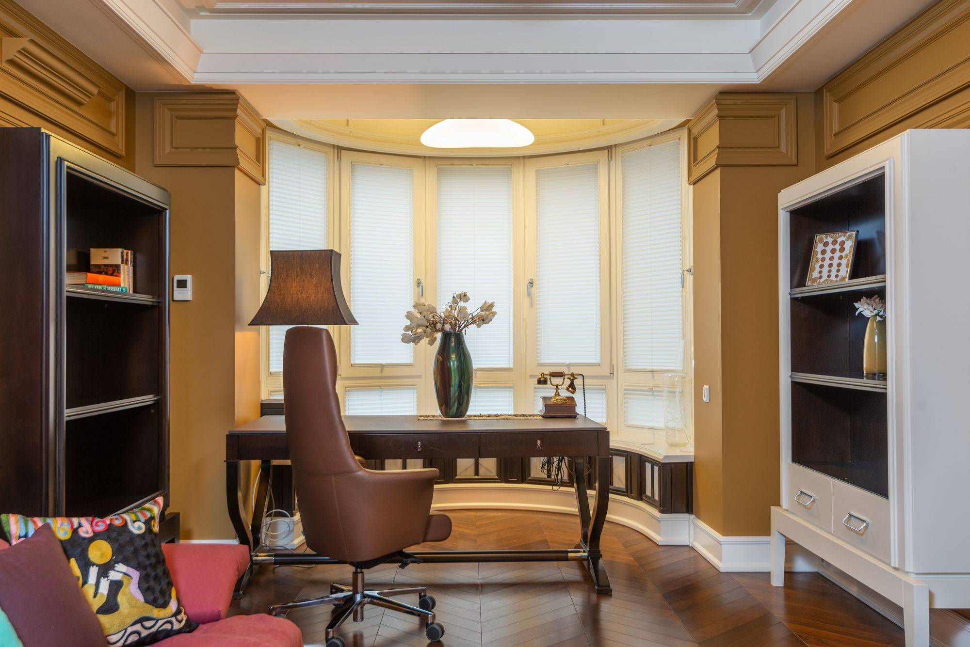 Study with a bay window and paneled millwork